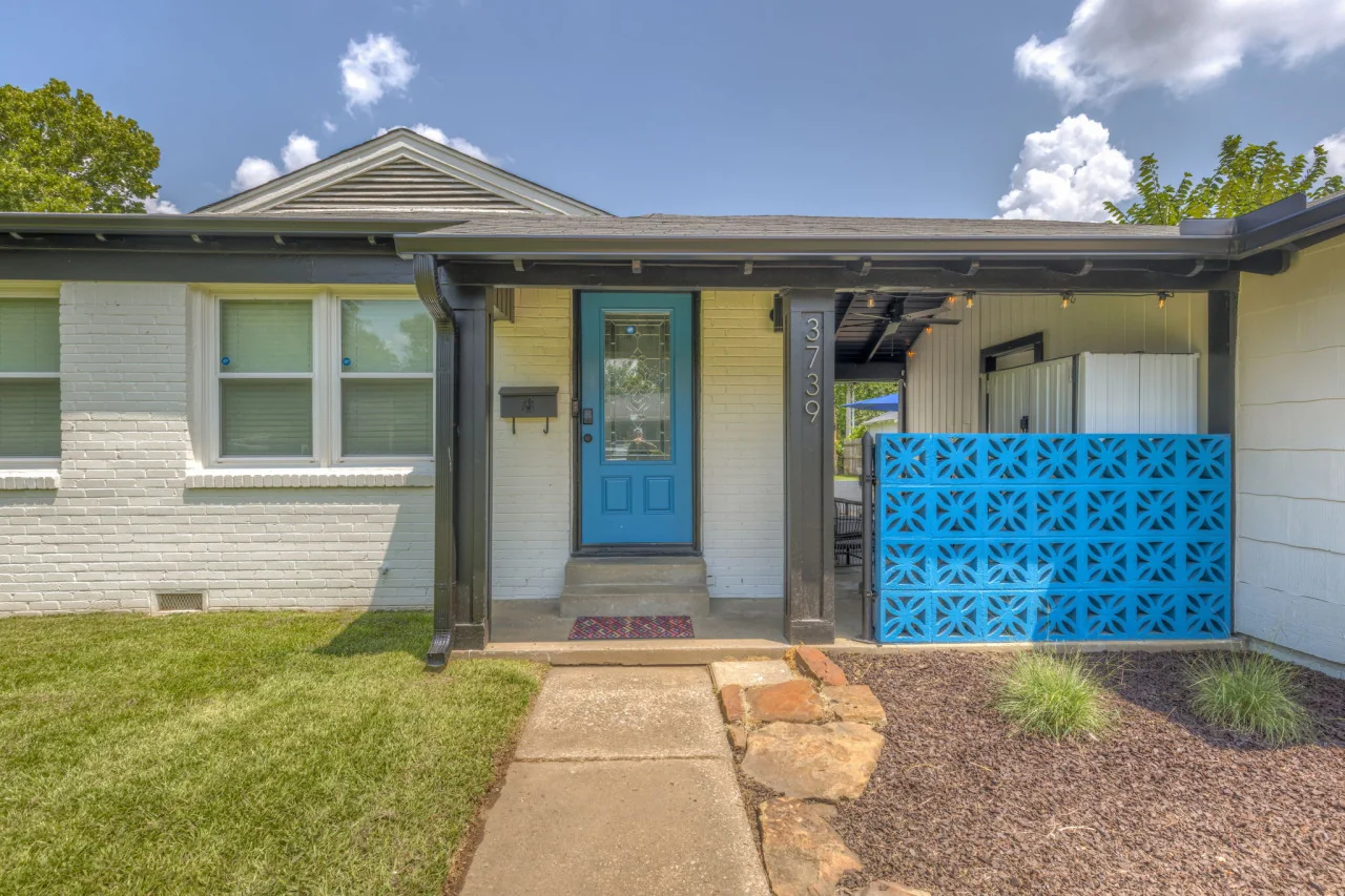 ModernNest vacation rental with a bright blue front door in Tulsa